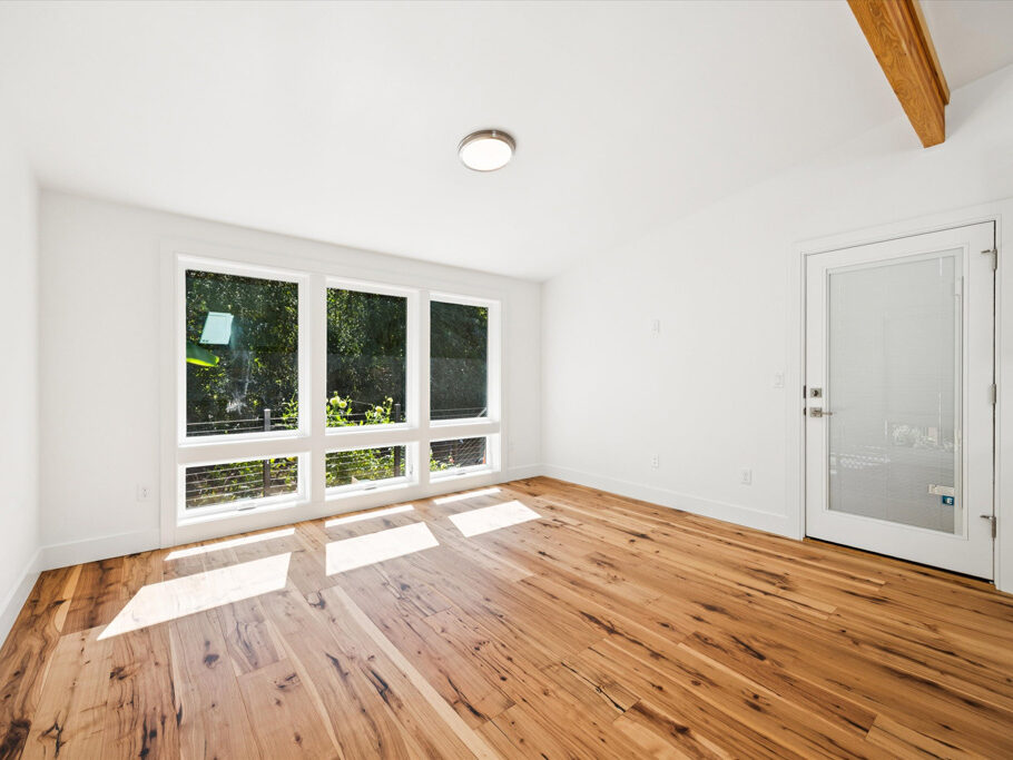 Contemporary attached ADU with large windows and hardwood floors.
