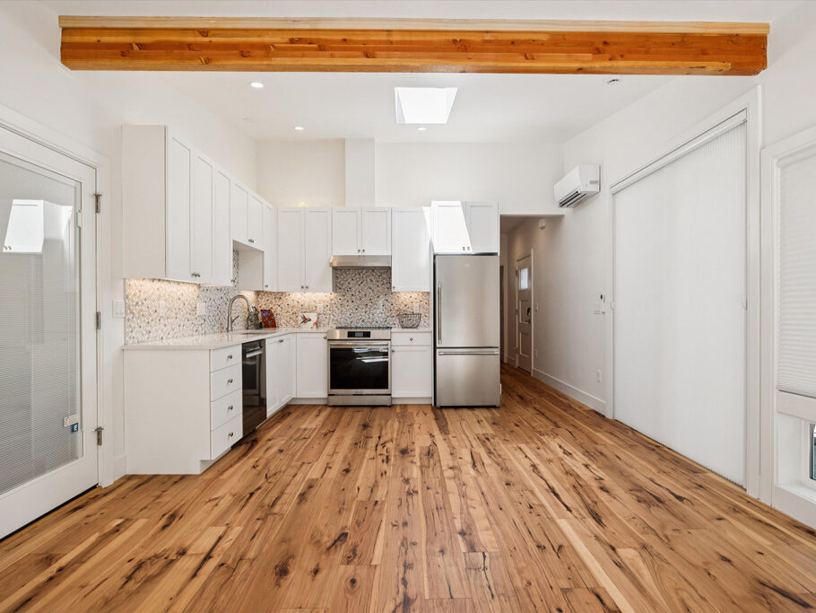Kitchen and great room in contemporary attached ADU with large windows and hardwood floors.