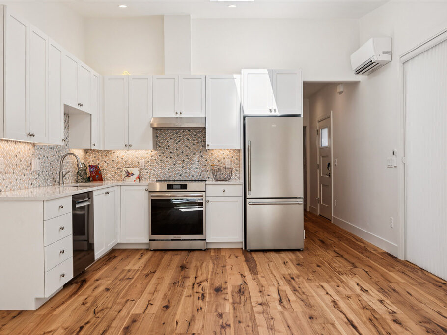 Kitchen and great room in contemporary attached ADU with large windows and hardwood floors.
