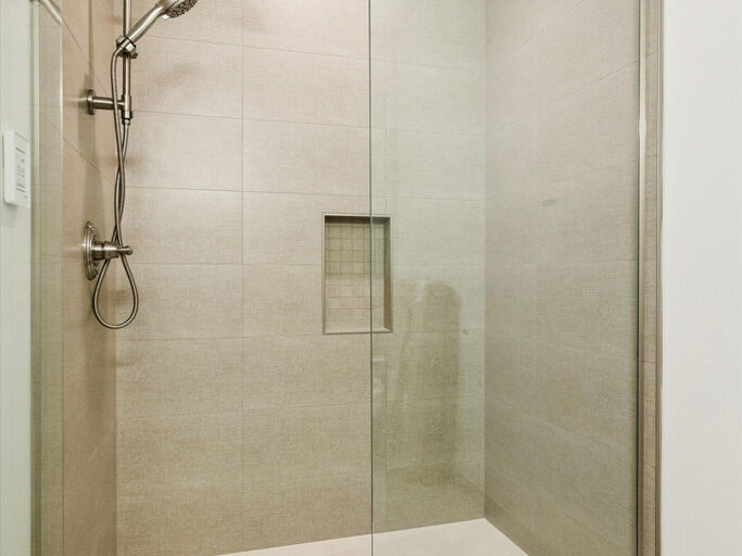 Bathroom in contemporary attached ADU with large windows and hardwood floors.